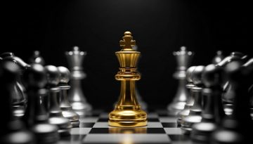 Alt-Text: Eine minimalistische Darstellung, bei der eine einzelne goldene Schachfigur (König) im Spotlight steht, während alle anderen grauen, unscharfen Figuren im Hintergrund bleiben. Der Fokus liegt klar auf der Einzigartigkeit und dem herausragenden Status. Der Stil ist fotorealistisch mit dramatischem Licht. → Eine goldene Schachfigur im Spotlight symbolisiert eine starke Expertenpositionierung.