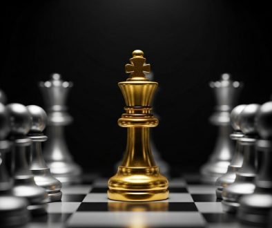 Alt-Text: Eine minimalistische Darstellung, bei der eine einzelne goldene Schachfigur (König) im Spotlight steht, während alle anderen grauen, unscharfen Figuren im Hintergrund bleiben. Der Fokus liegt klar auf der Einzigartigkeit und dem herausragenden Status. Der Stil ist fotorealistisch mit dramatischem Licht. → Eine goldene Schachfigur im Spotlight symbolisiert eine starke Expertenpositionierung.