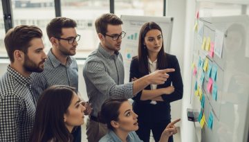 Ein engagiertes Team bei der Anwendung von Teamentwicklungsmethoden an einem Whiteboard.